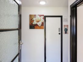 A hallway with a door and wall art at Dannevirke Lodge - Dannevirke