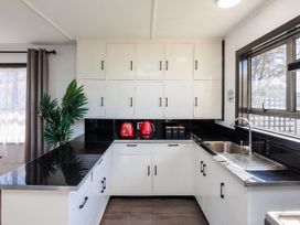 A kitchen with cabinets and a sink at Dannevirke Lodge - Dannevirke