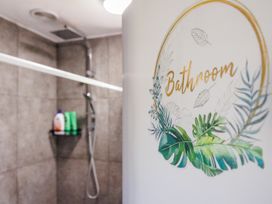 A bathroom with shower and shelf containing toiletries at Dannevirke Lodge - Dannevirke