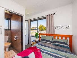 A bedroom with a bed and an attached bathroom at Dannevirke Lodge - Dannevirke