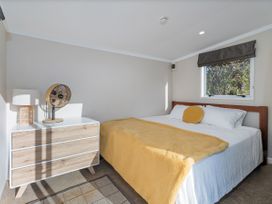 A bedroom with a bed and dresser at Little Tui Ridge - Coromandel Holiday Home Coromandel