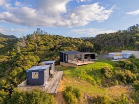 An outdoor area with cabins and a deck at Little Tui Ridge - Coromandel