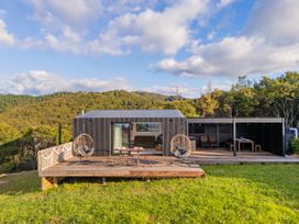 A house with a deck and outdoor seating at Little Tui Ridge - Coromandel Holiday Home, Coromandel