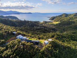A scenic view of the ocean and mountains with houses at Little Tui Ridge - Coromandel