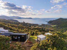 An outdoor view of cabins overlooking the sea at Little Tui Ridge - Coromandel
