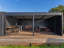 An outdoor dining area with a table and chairs at Little Tui Ridge - Coromandel