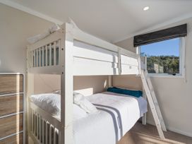 A bunk bed with a mattress and linens in a bedroom at Little Tui Ridge - Coromandel