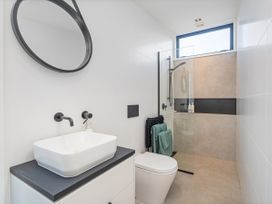 A bathroom with a sink and shower at Little Tui Ridge - Coromandel Holiday Home Coromandel
