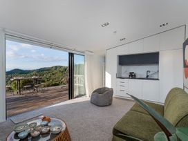 A living room with kitchen and outdoor view at Little Tui Ridge - Coromandel Holiday Home, Coromandel