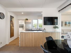 A kitchen with a kitchen island and appliances at The Wallnutt Grove - Waihi Beach