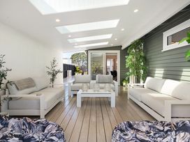 An outdoor lounge area with sofas and a table at The Wallnutt Grove - Waihi Beach