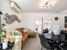 A living room with a sofa and decorative wall art at The Wallnutt Grove - Waihi Beach