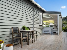 A wooden table and chairs on the patio at The Wallnutt Grove - Waihi Beach