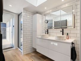 A bathroom with sinks and mirrors at The Wallnutt Grove - Waihi Beach