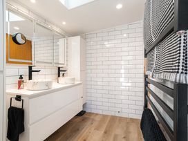 A bathroom with sinks and a mirror at The Wallnutt Grove - Waihi Beach