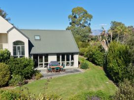 An outdoor dining area with a table and chairs at Vineyard View - Blenheim Holiday Home