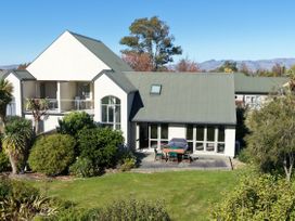 An outdoor dining area with a table and chairs at Vineyard View - Blenheim Holiday Home in Blenheim