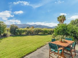 A garden with a table and chairs at Vineyard View - Blenheim Holiday Home