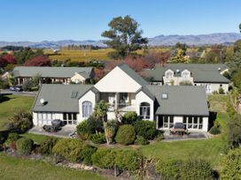 An outdoor view of a building with garden and mountains at Vineyard View - Blenheim Holiday Home in Blenheim