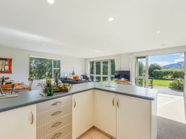 A kitchen with a counter and bottles at Vineyard View - Blenheim Holiday Home in Blenheim