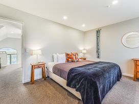 A bedroom with a bed and nightstands at Vineyard View - Blenheim Holiday Home