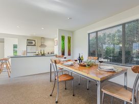 A dining room with a table set for a meal at Vineyard View - Blenheim Holiday Home