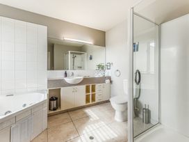 A bathroom with a bathtub, shower, toilet, and sink at Vineyard View - Blenheim Holiday Home, Blenheim