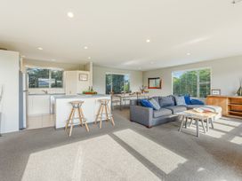 A living room with a kitchen and dining area at Vineyard View - Blenheim Holiday Home