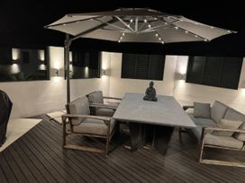 A patio with a table, chairs, and an umbrella at Fernwood Escape - Tauranga Holiday Retreat, Tauranga