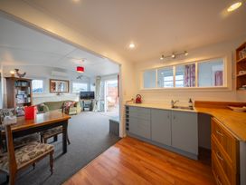 A kitchen and living room area with a dining table at Dragon Fly Cottage - Te Anau