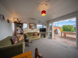 A living room with a sofa and television at Dragon Fly Cottage - Te Anau Holiday Home Te Anau