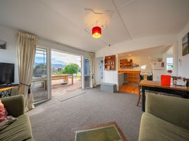 A living room with a television and sofa at Dragon Fly Cottage - Te Anau