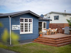 An outdoor seating area with a table and chairs at Dragon Fly Cottage - Te Anau