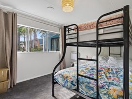 A bedroom with a bunk bed and a double bed at Ruakaka Holiday Home in Ruakaka