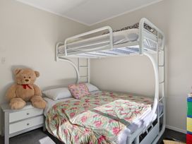 A bedroom with a bunk bed and teddy bear at Ruakaka Holiday Home in Ruakaka