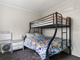 A bedroom with a bunk bed and a nightstand at Ruakaka Holiday Home in Ruakaka