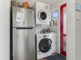 A laundry room with washing machine and dryer at Ruakaka Holiday Home Ruakaka