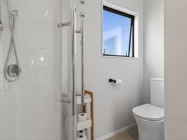 A bathroom featuring a shower and a toilet at Ruakaka Holiday Home in Ruakaka