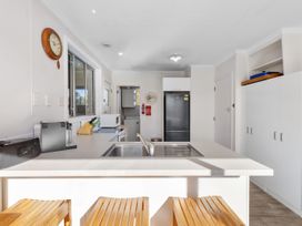 A kitchen with appliances and seating at Get Away By The Green - Cromwell