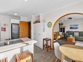 A kitchen with a sink and refrigerator at Get Away By The Green - Cromwell Holiday Home, Cromwell