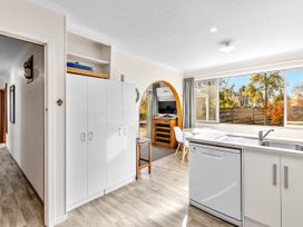 A kitchen with a dishwasher and cabinets at Get Away By The Green - Cromwell