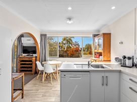 A kitchen with a sink and dining table at Get Away By The Green - Cromwell