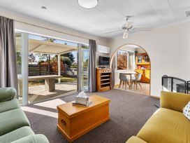 A living room with a coffee table and dining area at Get Away By The Green - Cromwell