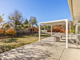 An outdoor patio with a table and pergola at Get Away By The Green - Cromwell