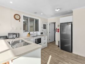 A kitchen with appliances and a window at Get Away By The Green - Cromwell