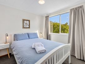 A bedroom with a bed and bedside lamps at Get Away By The Green - Cromwell