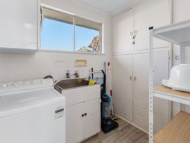 A laundry room with a washing machine and sink at Get Away By The Green - Cromwell