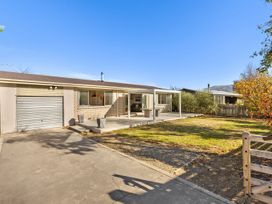 A house with a garage and patio at Get Away By The Green - Cromwell