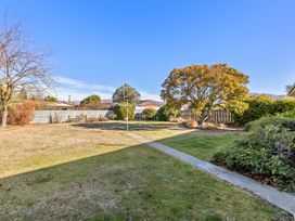 A garden with grass and a clothesline at Get Away By The Green - Cromwell