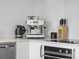A kitchen with an espresso machine and kettle at Te Ohu - Wanaka Holiday Home in Wanaka